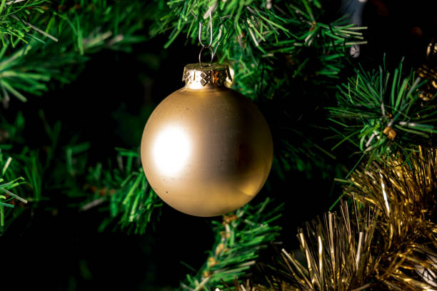 istock a christmas ball on artificial tree. close up of a decorated christmas tree. light reflected on golden christmas ball 1627510450