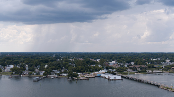 Tree lined neighborhood and river pier against moody sky. Road bridge from Fort Monroe to Phoebus in Hampton, VA