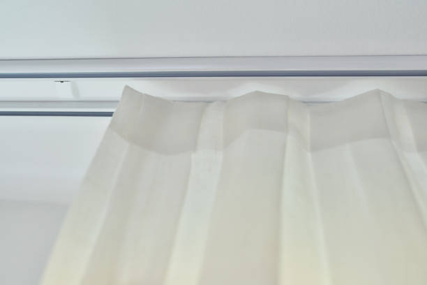 istock Translucent white textured curtain on window, close-up of cornice and fabric gathered on braid 1627577290