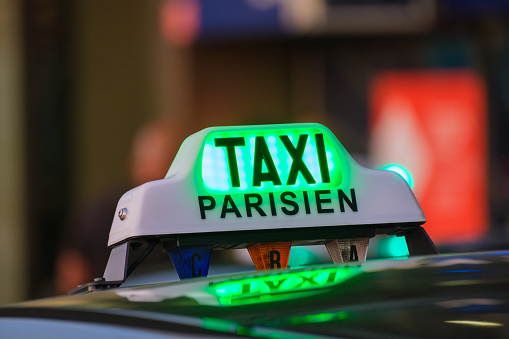 Close-up of green Paris taxi sign on a car at Orly airport