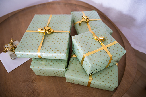 Gifts wrapped in green gift paper with yellow ribbon.