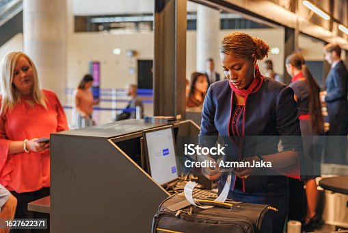 istock Blonde Caucasian Woman Being Helped By An African Stewardess 1627622371