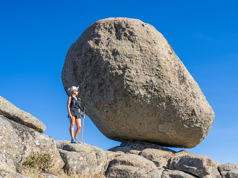 Woman between large granite boulders in the Sierra de Béjar, Spain
