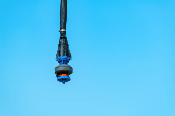 Agricultural irrigation water sprinkler outdoors against blue sky, selective focus