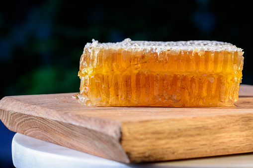 Honey. natural honey and honeycomb. Close up on delicious organic honeycomb on a wooden cutting board.