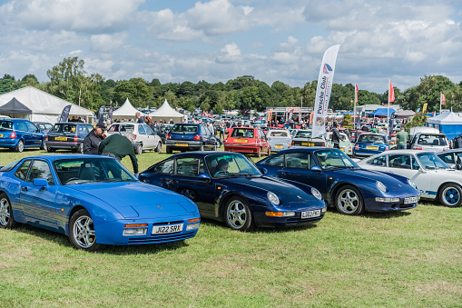 Tarporley, Cheshire, England, July 29th 2023. Blue Porsche 944 and Porsche 911's at a car meet club stand, automotive lifestyle illustration.