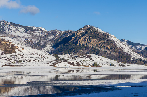 a scenic reflection landscape of the Teton Range in Jackson Lake in Grand Teton National Park Wyoming in springtime