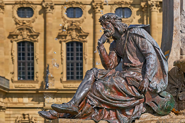 Wuerzburg, Germany - May 17, 2023: Bronze statue by Walther von der Vogelweide at the restored Frankonia fountain in front of the residence.