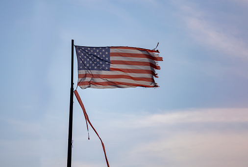 A Weathered and Torn American Flag blowing in the wind