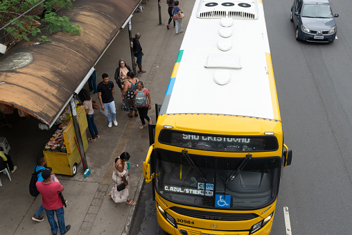 Salvador, Bahia, Brazil - August 11, 2023: People are seen standing at the bus stop on Avenida Tancredo Neves, a commercial center in the city of Salvador, Bahia.