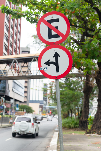 Salvador, Bahia, Brazil - August 11, 2023: A traffic sign that indicates that it is forbidden to stop and another that informs you to turn left and go straight ahead. city of Salvador, Bahia.