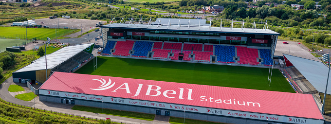 Aerial shot of AJ Bell rugby Stadium on the side of a river.