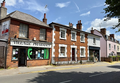 Writtle, UK - July 12, 2023: Village Pharmacy, pretty residential houses and a shop on a street in the delightful village of Writtle in Essex, England.