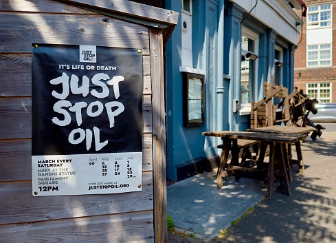 London, UK - June 15, 2023: A poster on a wooden shed encouraging the public to join a Just Stop Oil march every week in Parliament Square, London, UK.