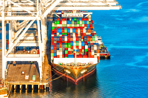 A large cargo ship moored at the Port of Houston unloading containers  to the dock at Morgan's Point located along the Houston Shipping Channel just west of Galveston Bay shot from a helicopter at an altitude of about 400 feet  over the river.