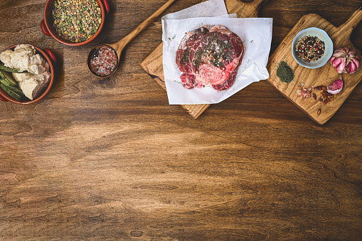 Cooking concept with spices and beef on wooden background.