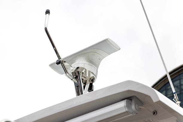 Radar and Communication Antennas on the Mast of a Fishing Vessel Against a Clear Blue Sky