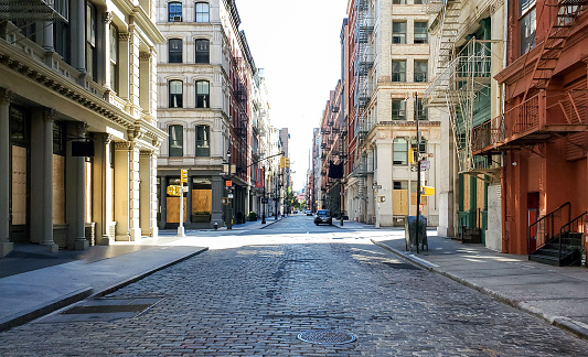 Empty streets and sidewalks of Soho are eerily quiet during the 2020 coronavirus pandemic lockdown in New York City at sunset with no people
