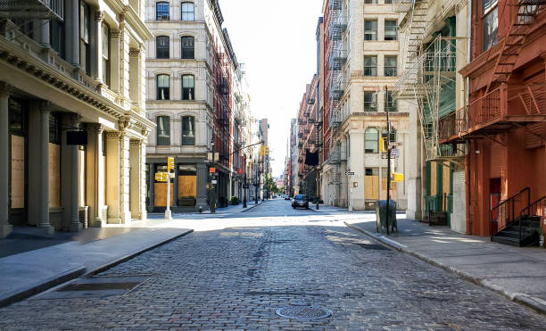 Empty streets and sidewalks of Soho are eerily quiet during the 2020 coronavirus pandemic lockdown in New York City with no people and sunset background stock photo