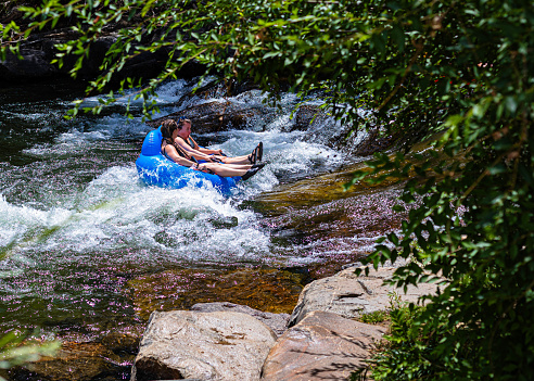 Golden, Colorado, USA, August 12, 2023, Two female river tubers  in rapids with surprised expression on Clear Creek