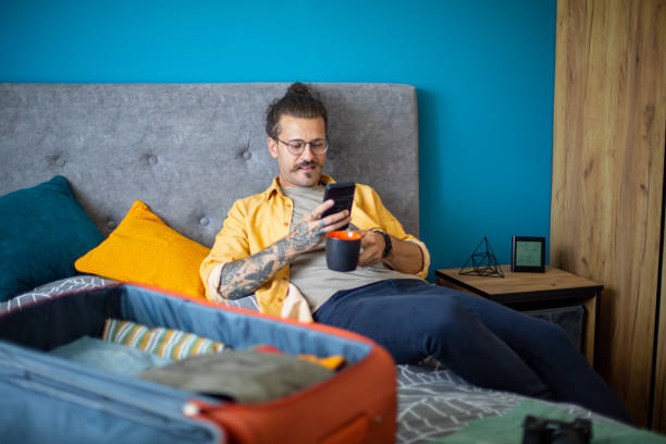 istock Man is packing his suitcase and using a mobile phone 1628075307