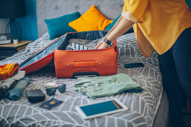 istock Man packing his suitcase in his bedroom, getting ready for travel 1628078358