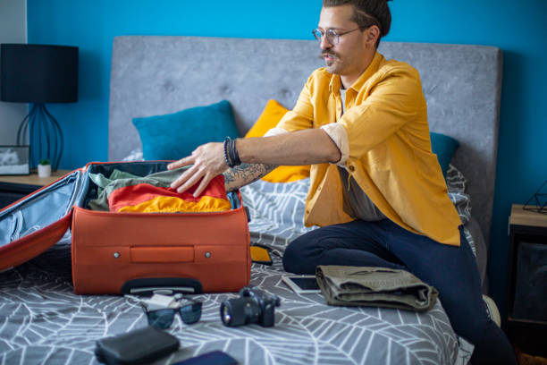 istock Man packing his suitcase in his bedroom, getting ready for travel 1628079499