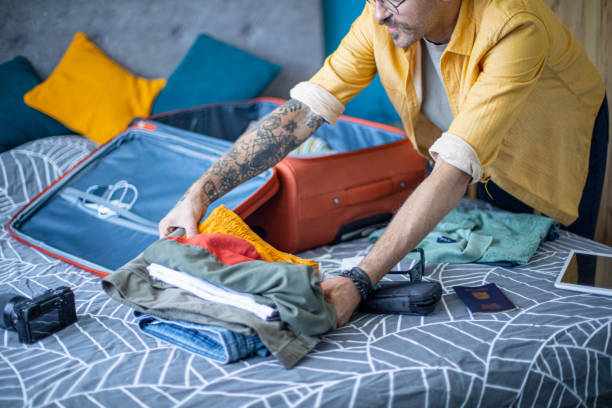 istock Man packing his suitcase in his bedroom, getting ready for travel 1628080445