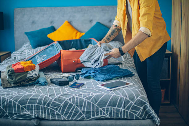 istock Man packing his suitcase in his bedroom, getting ready for travel 1628083072