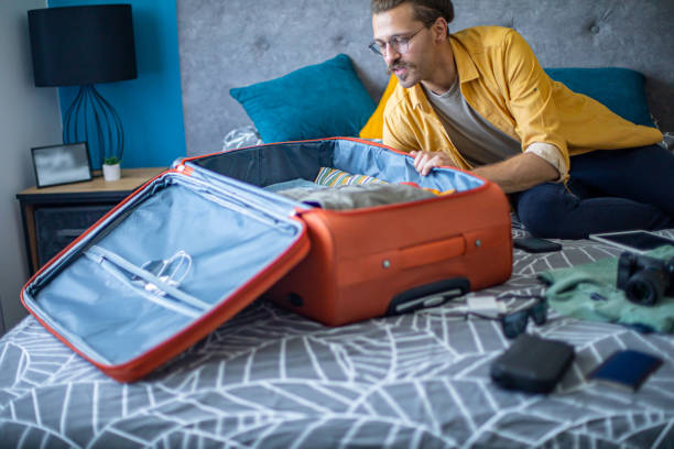 istock Man packing his suitcase in his bedroom, getting ready for travel 1628085298