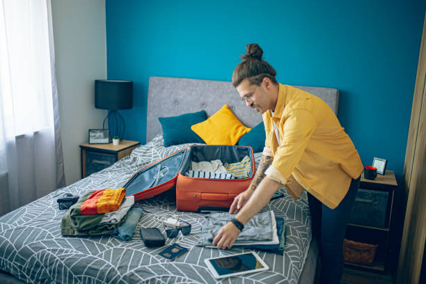 istock Man packing his suitcase in his bedroom, getting ready for travel 1628094709