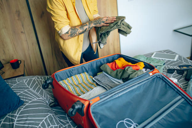 istock Man packing his suitcase in his bedroom, getting ready for travel 1628095246
