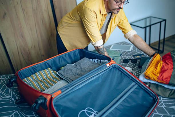 istock Man packing his suitcase in his bedroom, getting ready for travel 1628102195