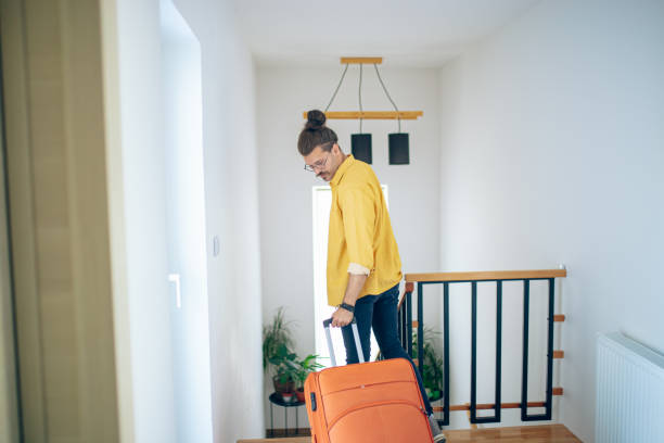 istock Man walks through the corridor and goes on a trip with a suitcase 1628103767