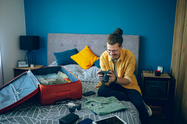 istock Man is packing his suitcase and checking his camera 1628107499