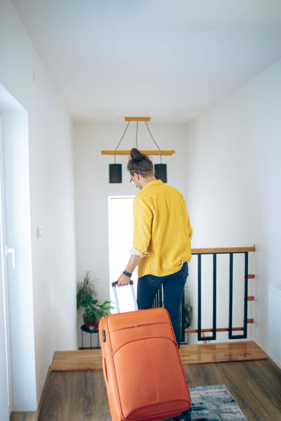 istock Man walks through the corridor and goes on a trip with a suitcase 1628107921