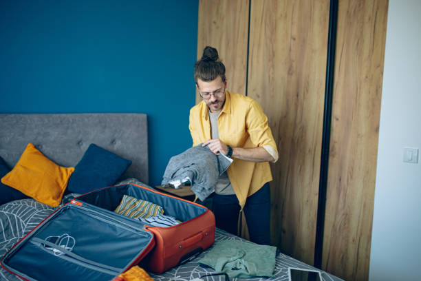 istock Man packing his suitcase in his bedroom, getting ready for travel 1628110601