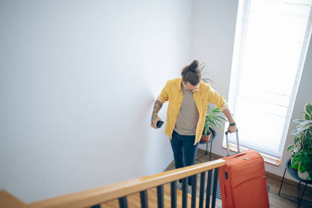 istock Man carrying his luggage up a staircase 1628111371