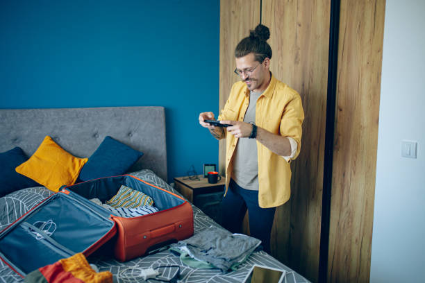 istock Man packing his suitcase in his bedroom, getting ready for travel 1628113312