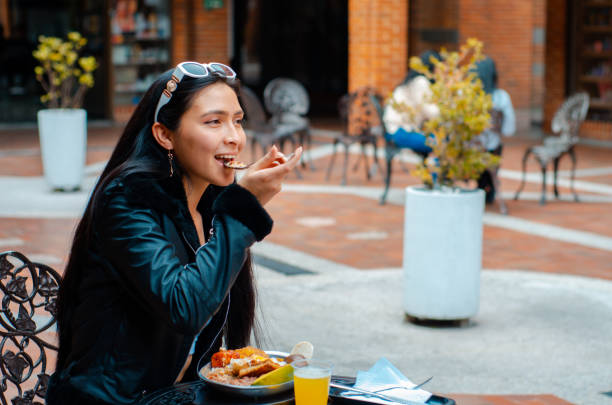young woman eating colombian food stock photo