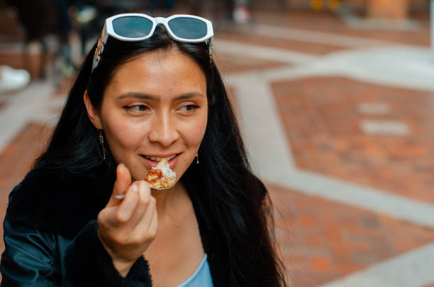 Portrait of young woman eating colombian food stock photo