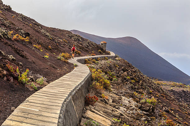 On Volcanic Footpath, La Palma Woman walking on the Volcano Route, a path that crosses volcanic landscapes of extraordinary beauty where you can admire the different features of the La Palma island. This photo was taken around the Volcano of Teneguía, whose last eruption dates back to 1971, the last in the island. La Palma, Canary Islands, Spain. la palma canary islands photos stock pictures, royalty-free photos & images