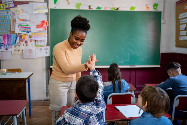 istock Cheerful black teacher celebrating her student answered correctly giving him a high five 1628195591