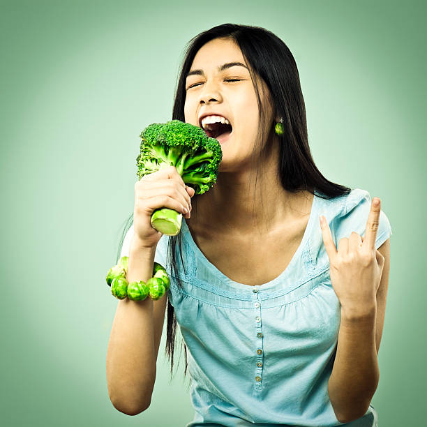 ragazza cantare nel microfono di rape - brussels sprout vegetable organic healthy eating foto e immagini stock