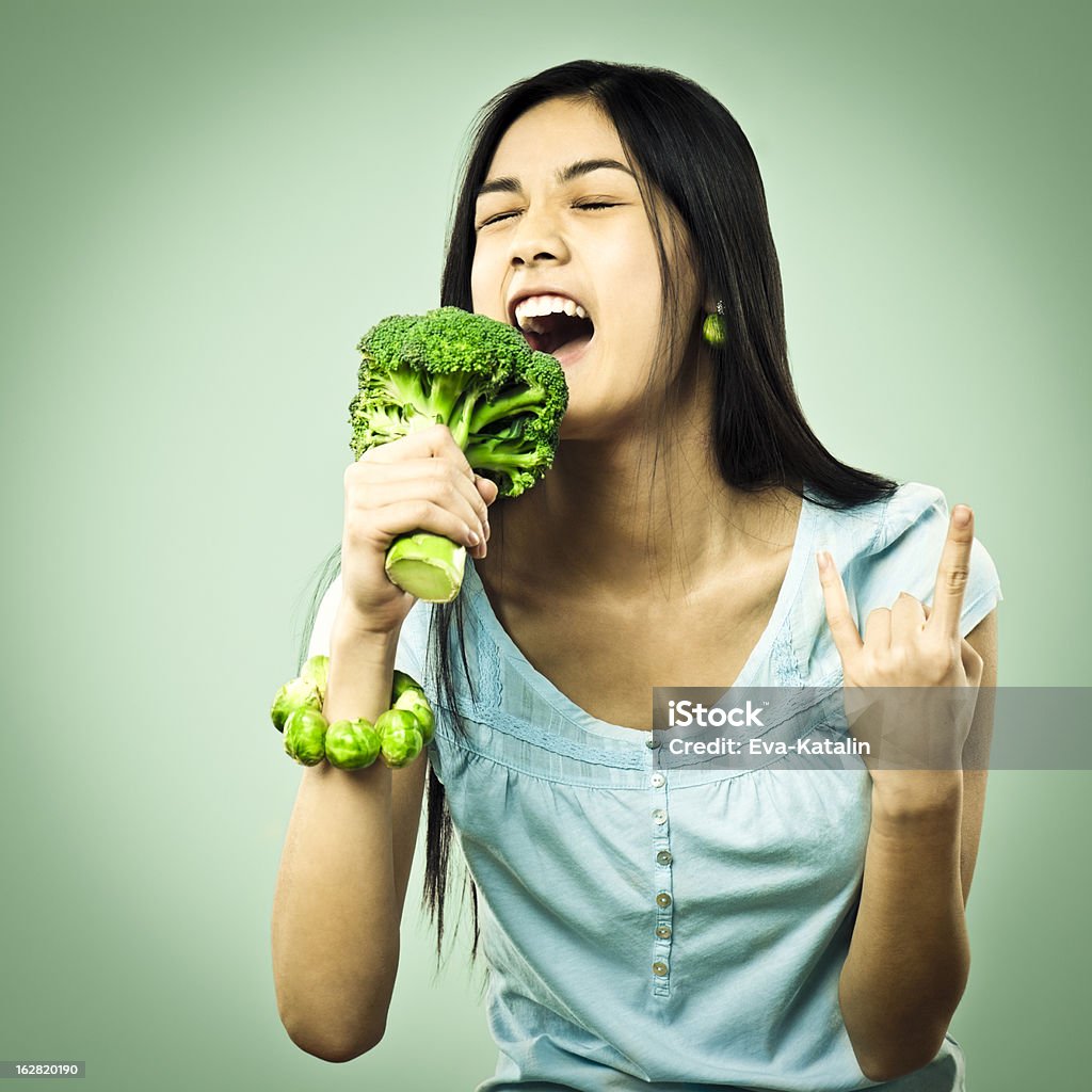 Girl singing in a broccoli microphone Singing Stock Photo