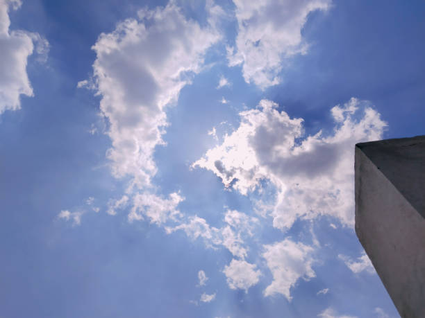 Sunbeam through the haze on blue sky. Sun light rays or beams bursting from the clouds on a blue sky. Spiritual religious background.