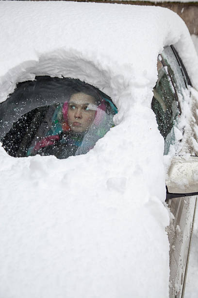 istock Woman driver surprised looking from behind a snowy car window 162823162