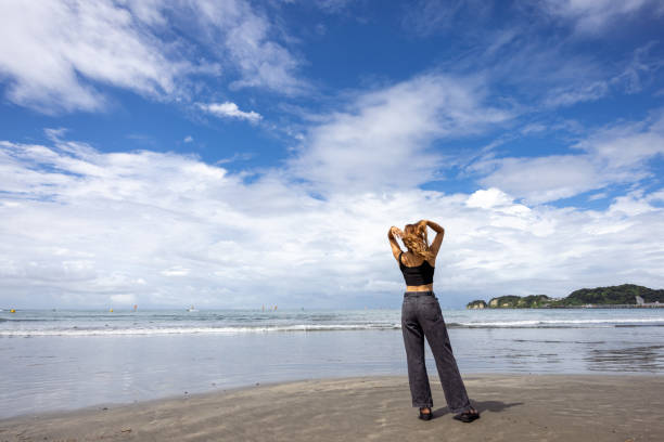 Rear view of woman visiting summer beach