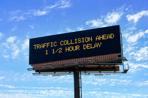 Electronic highway billboard with a traffic collision delay warning