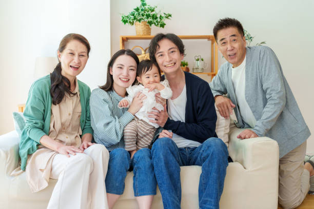 istock three generations asian family relaxing on sofa 1628267338